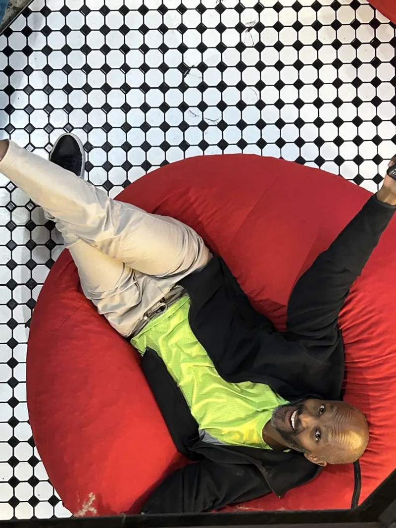 Michael grinning up at the camera from a red beanbag